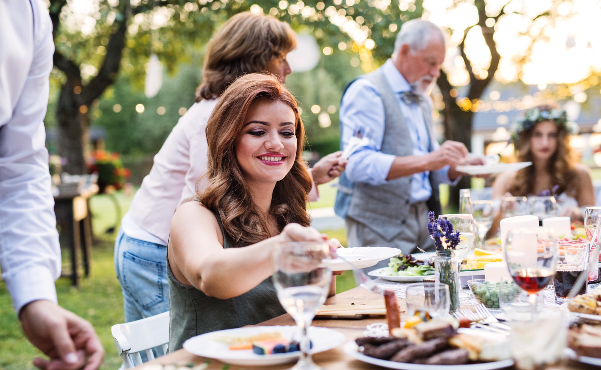 Guests eating at the wedding reception outside in the backyard.