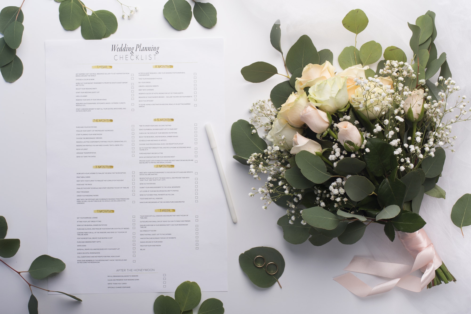 Bridal roses bouquet and planning checklist on white