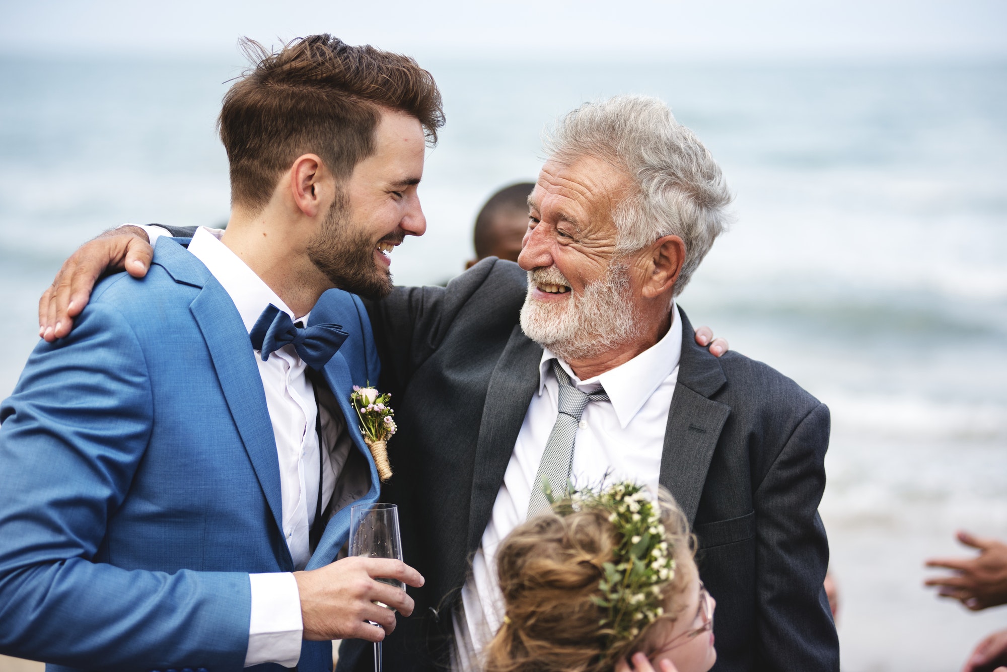 Two men hugging at beach a beach wedding